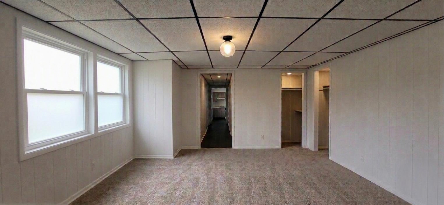 306 Woodward Unit 3 living area with large front windows and open closet storage