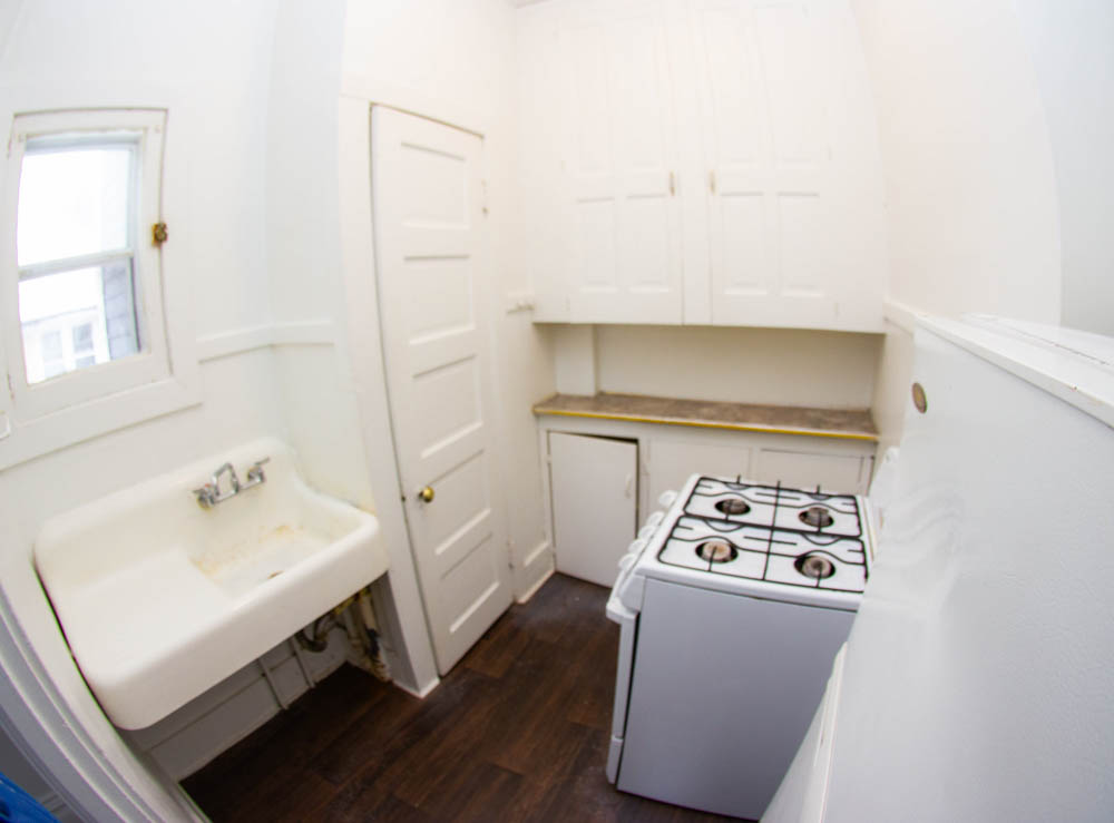 312 Unit 8 kitchen with sink, gas stove, and upper storage cabinets