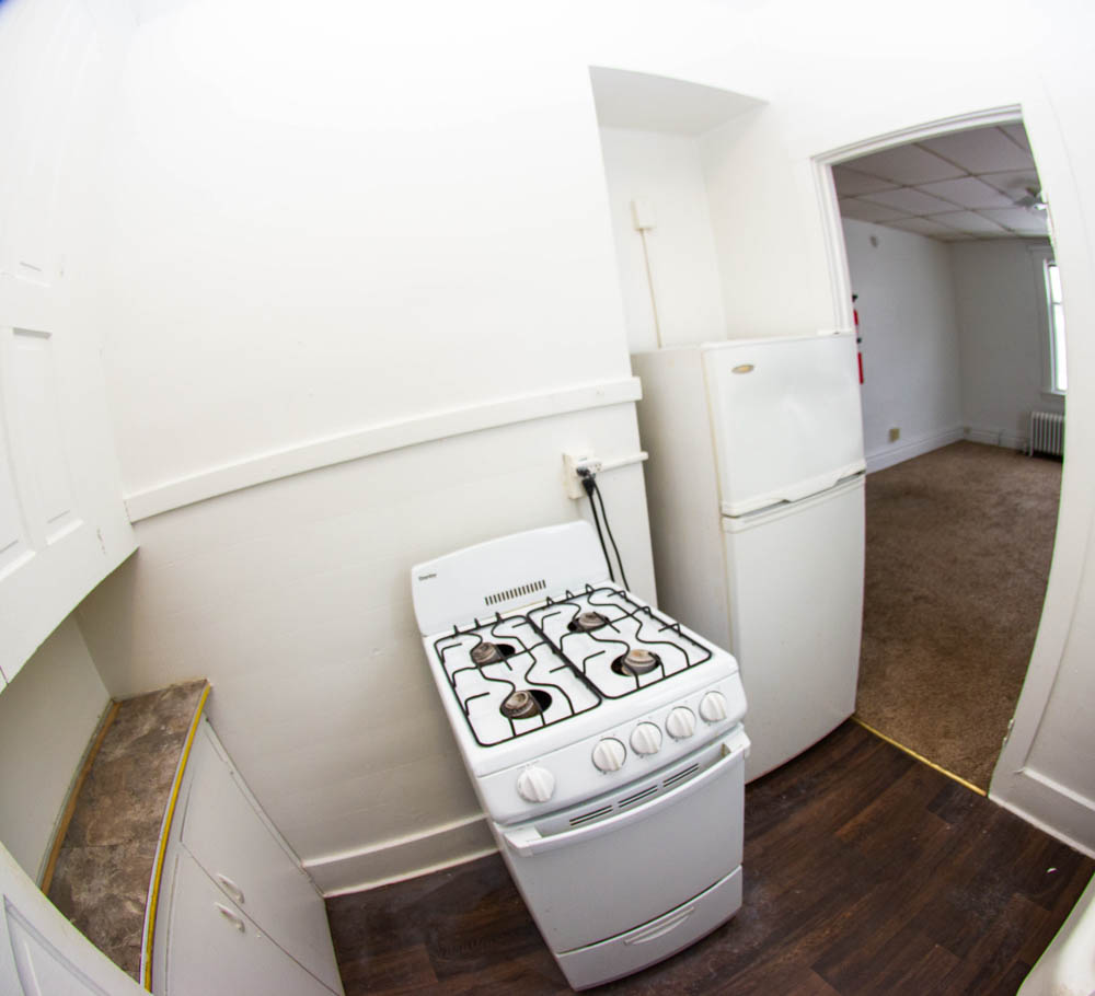 312 Unit 8 kitchen with stove, refrigerator, and opening to the living area