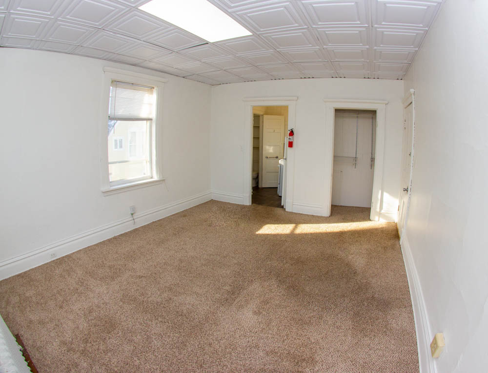 312 Unit 8 living area with high ceiling detail and closet view