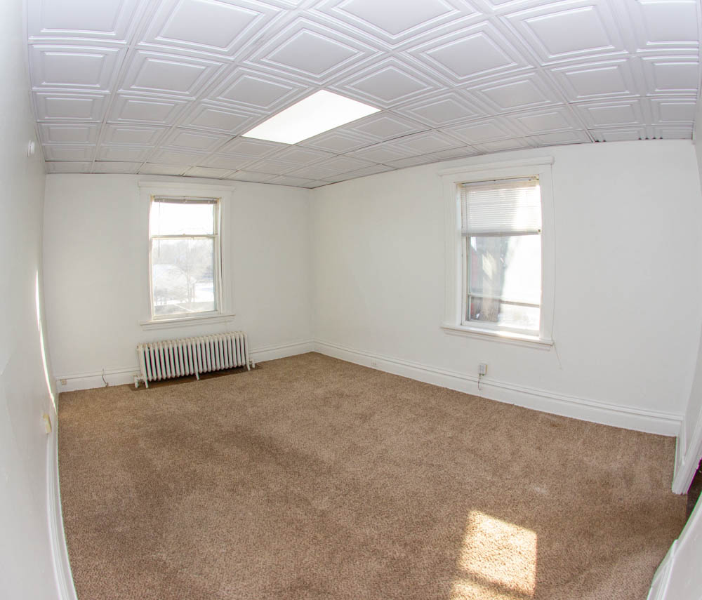 312 Unit 8 living area with radiator and two bright windows